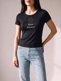 Worn by a woman: Her Baby Tee (Tencel), Cave Sorores on a black fitted Tencel baby tee with light blue jeans