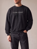 Worn by a man: Crewneck Sweater, CON·VENT on a washed black oversized crewneck sweatshirt