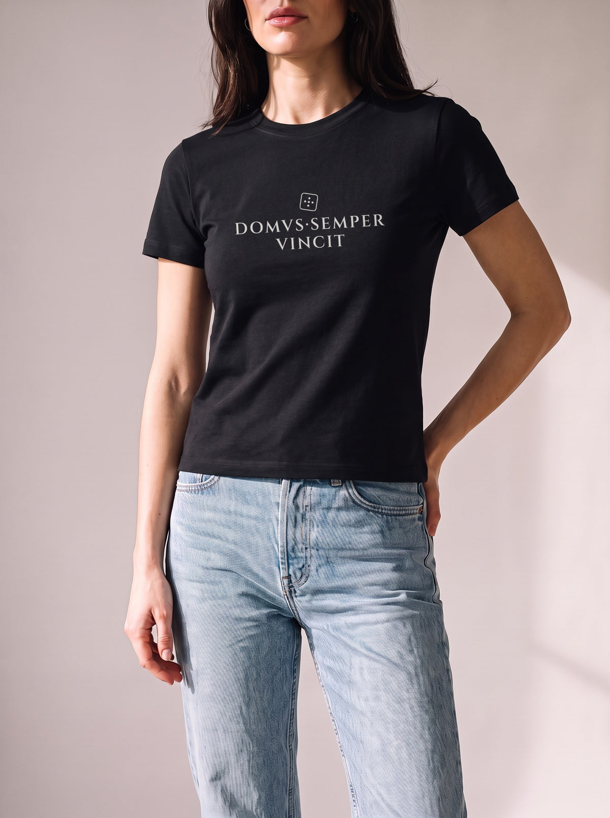 Worn by a woman: Her Baby Tee (Cotton), DOMVS·SEMPER VINCIT on a black slim cotton baby tee with light blue jeans