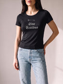 Worn by a woman: Her Baby Tee (Tencel), Sine Testibus on a black fitted Tencel baby tee with light blue jeans