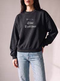 Worn by a woman: Crewneck Sweater, Sine Testibus on a washed black oversized crewneck sweatshirt