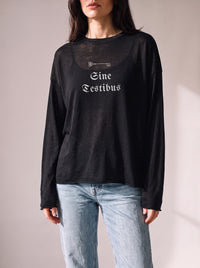 Worn by a woman: Her Sheer Long Sleeve, Sine Testibus on a black sheer raw-edge long sleeve over a black camisole