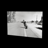 Lost Sister as a glossy aluminum print floating off a black wall, turning so the light moves across the metal